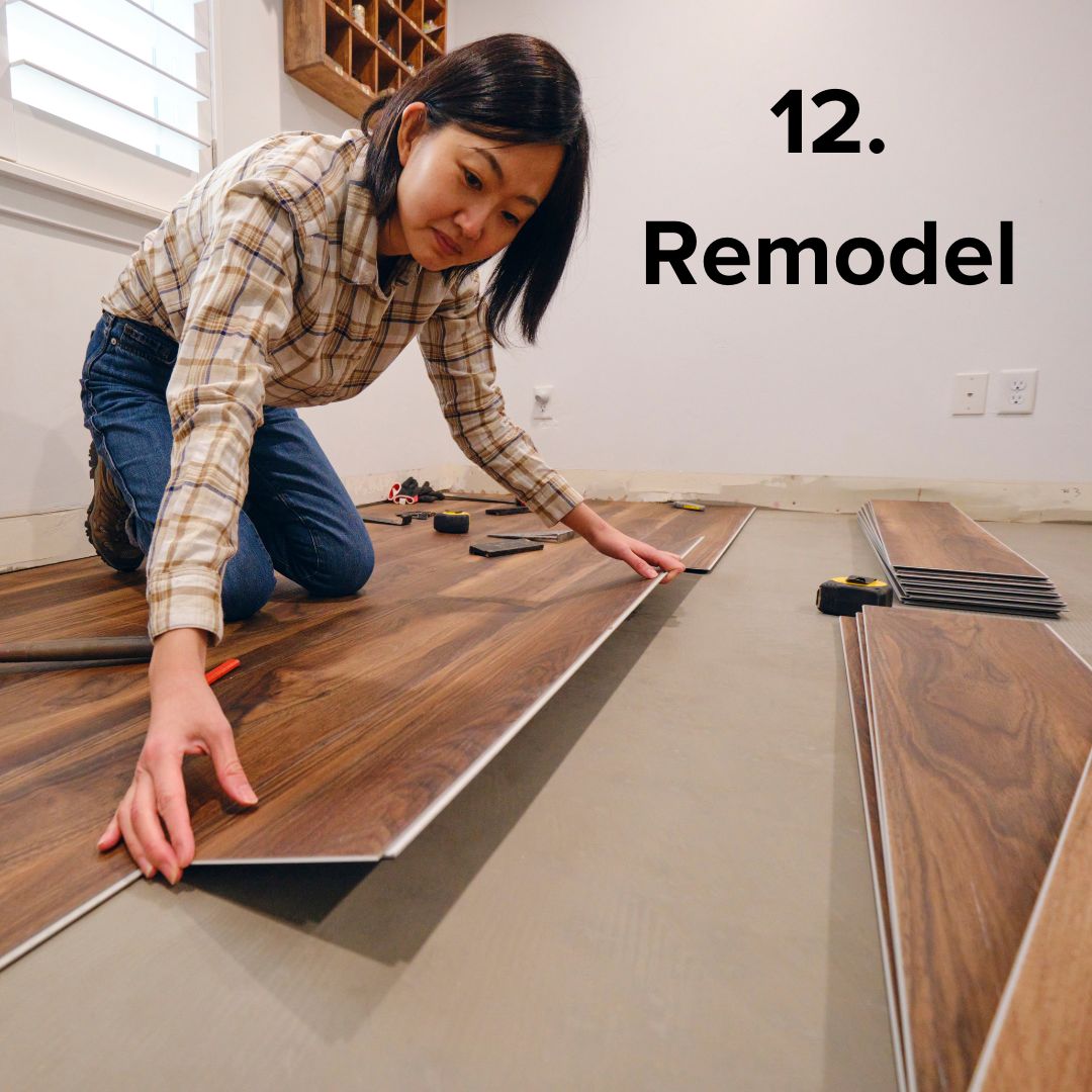 Title in black font in the upper-right: '12. Remodel.' A woman in a plaid shirt and jeans lays some new flooring as part of a remodel.