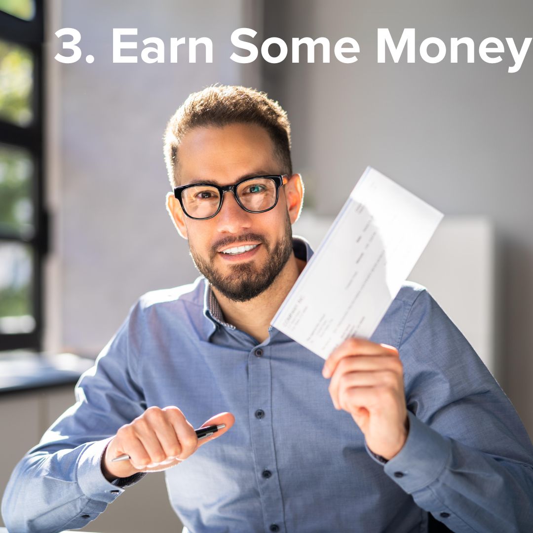 A man in an office wearing glasses and a blue buttoned-down Oxford holding a check and smiling. The title in white at the top says: '3. Earn Some Money.'