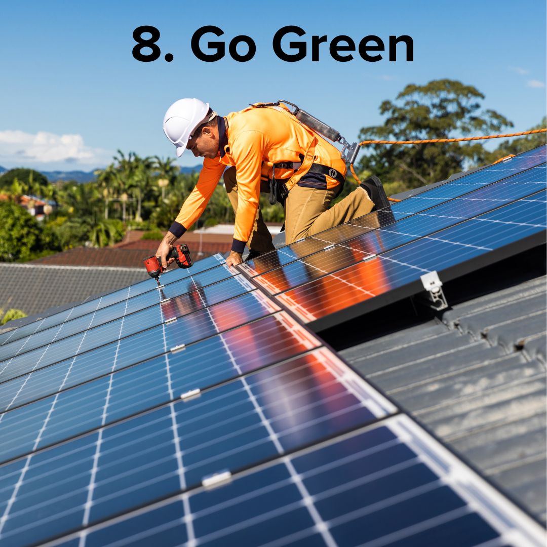 Photo of a man installing solar panels on a roof. The black title at the top is: '8. Go Green'
