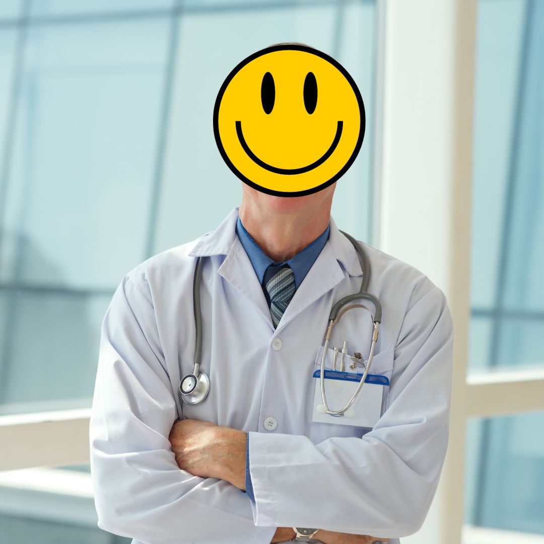 Physician in a white lab coat in a hospital with arms crossed. The head is replaced with a yellow smiley face.