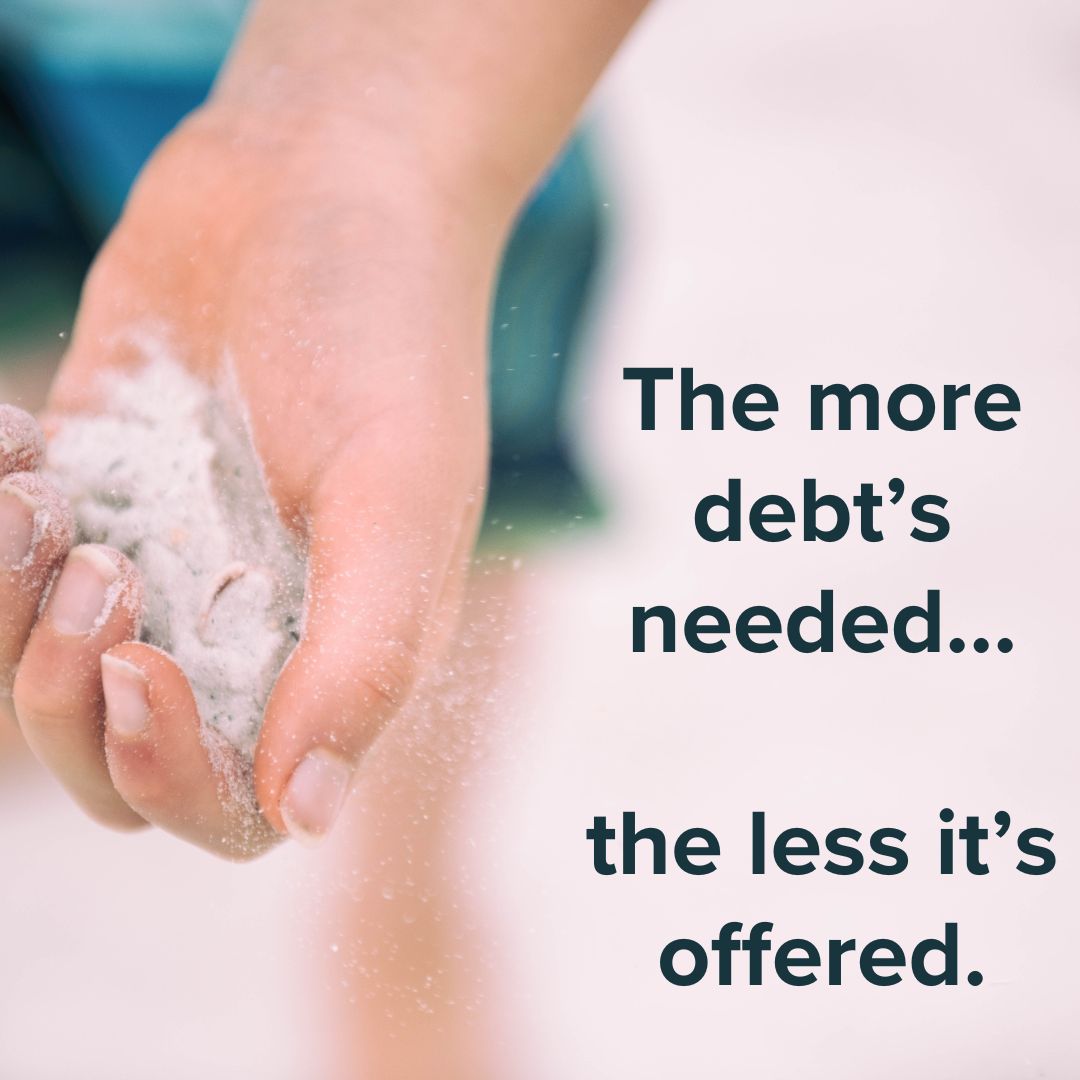 Title 'The more debt's needed... the less it's offered.' on the right. The background image is of someone holding sand in thelr left hand.