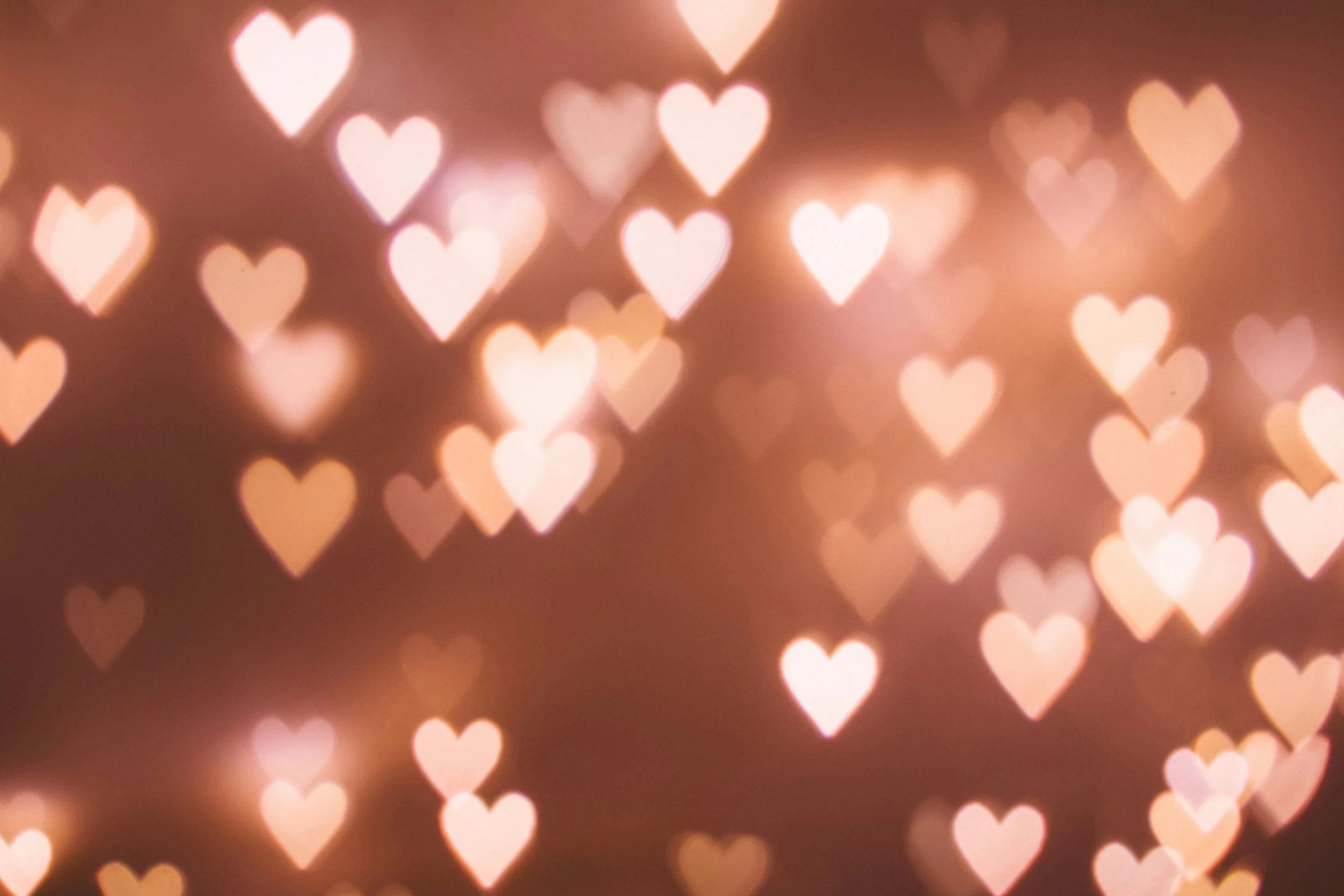 A photo of many heart shaped lights on a brown background.